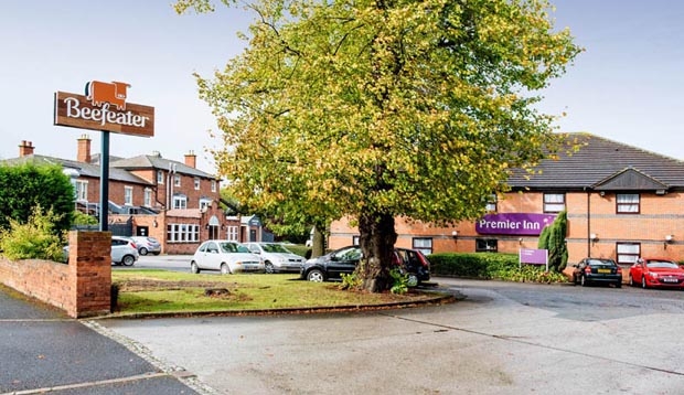 View of Premier Inn Cannock South hotel from the road showing Beefeater restaurant in the background with parking.