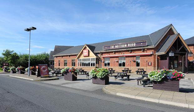 Exterior of Premier Inn Manchester (Hyde) hotel showing street view and car park