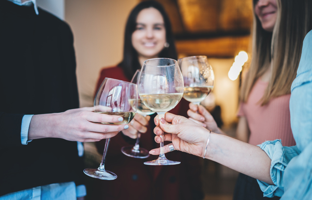 Freunde stoßen mit Wein an