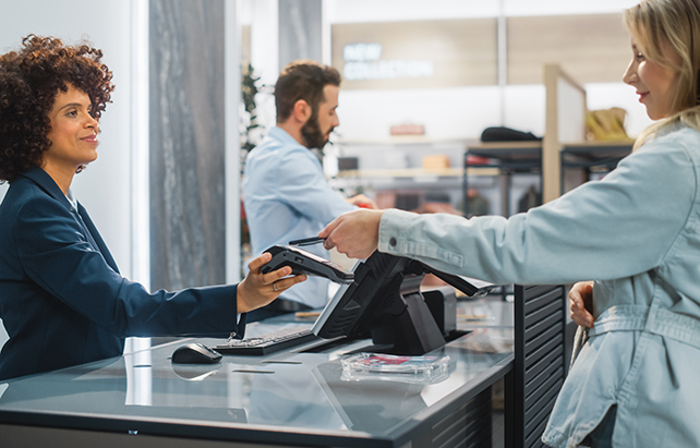 Frau bezahlt an Kasse mit Karte