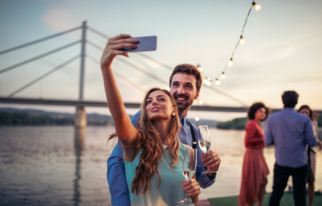 Junges Paar feiert auf Schiff und macht Selfies