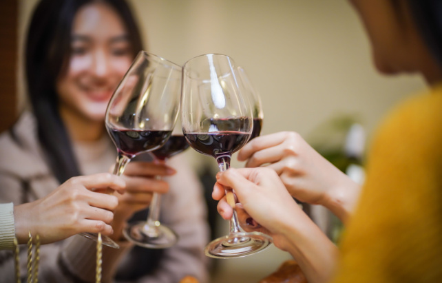 Freunde stoßen mit Rotwein an