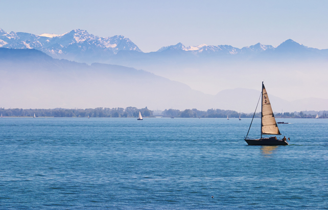 Boote am Bodensee mit den Alpen im Hintergrund
