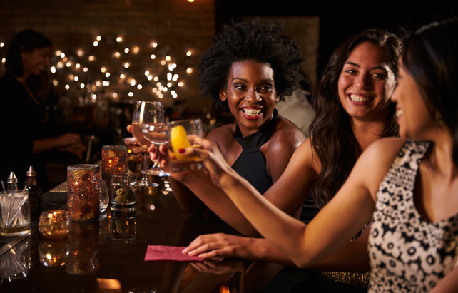 Freundinnen stoßen mit Cocktails an