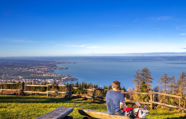 Junge blickt von einem Aussichtspunkt auf den Bodensee