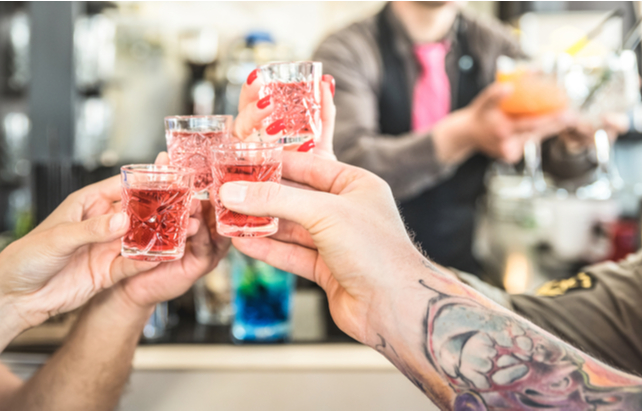 Freunde stoßen mit Shots an