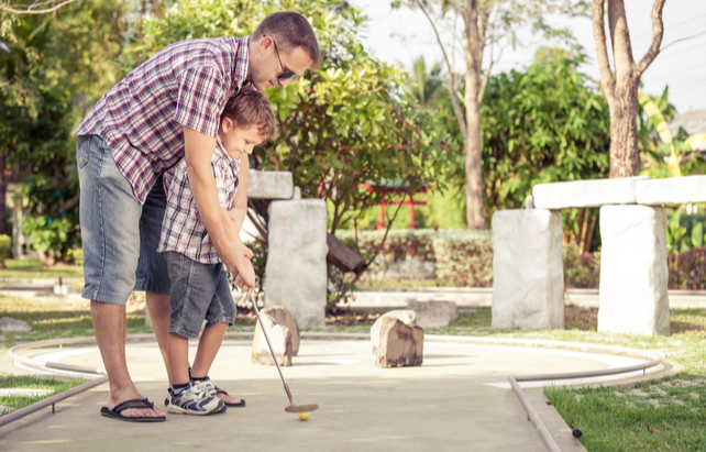 Vater und Sohn beim Golfspielen