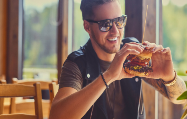Mann isst einen Burger im Restaurant