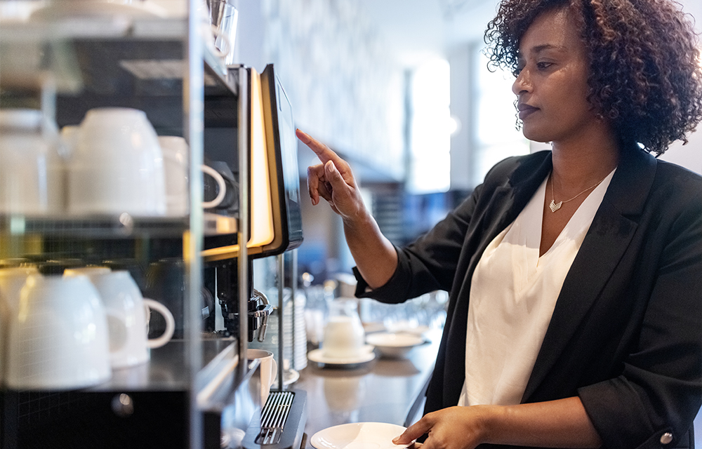 Frau am Kaffeeautomaten