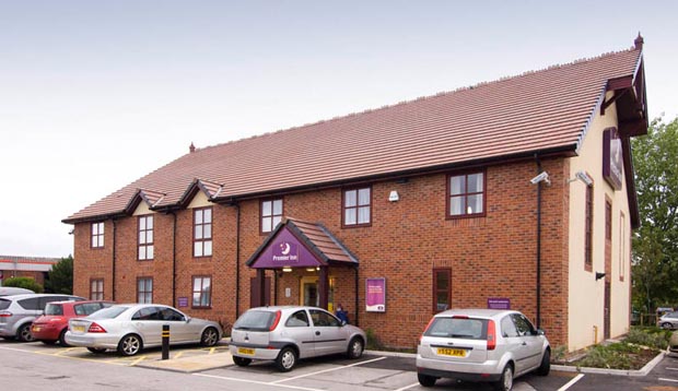 Front door of Premier Inn Crewe hotel with free parking spaces outside.