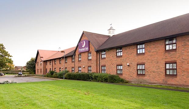 Exterior of Premier Inn Crewe West hotel with grassy area