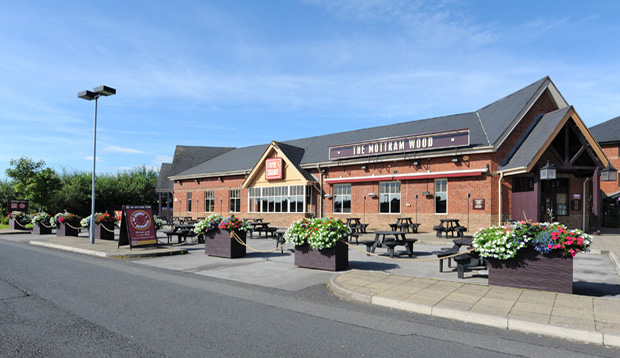 Exterior of Premier Inn Manchester (Hyde) hotel showing street view and car park